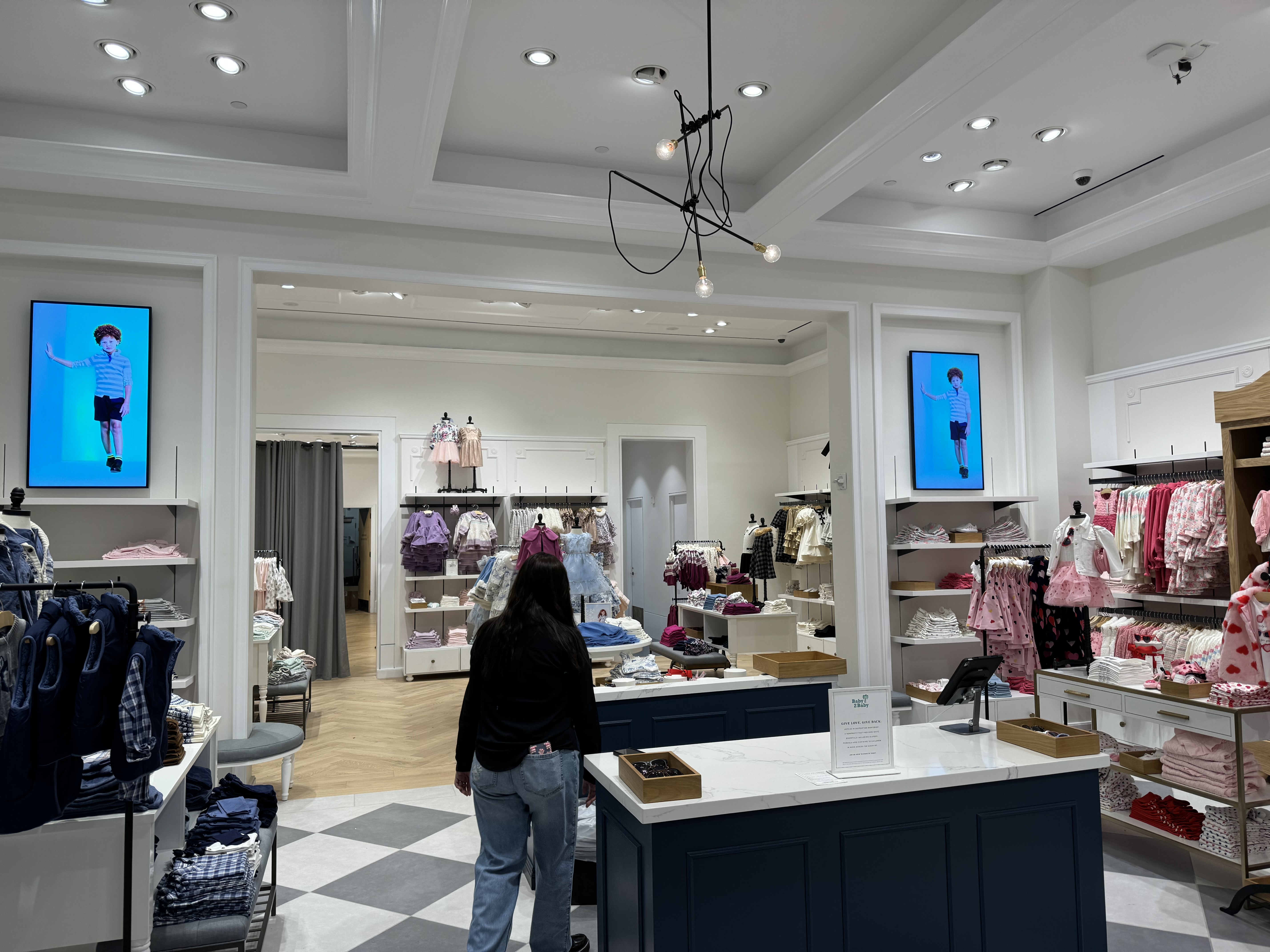 Samsung commercial display deployed inside a Janie and Jack retail location — representative QM-series install context.