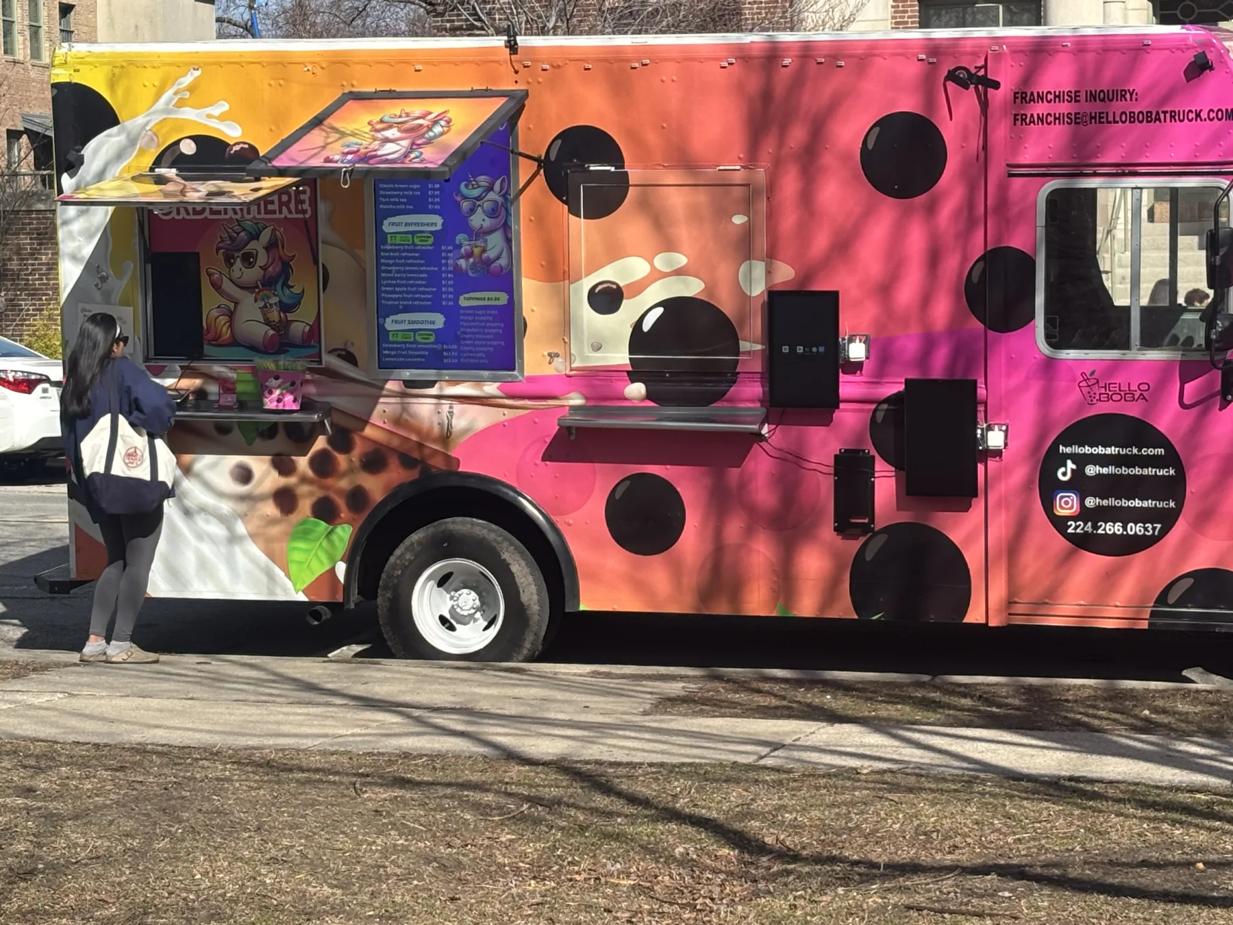 Outdoor digital menu board display on a Hello Boba Truck.