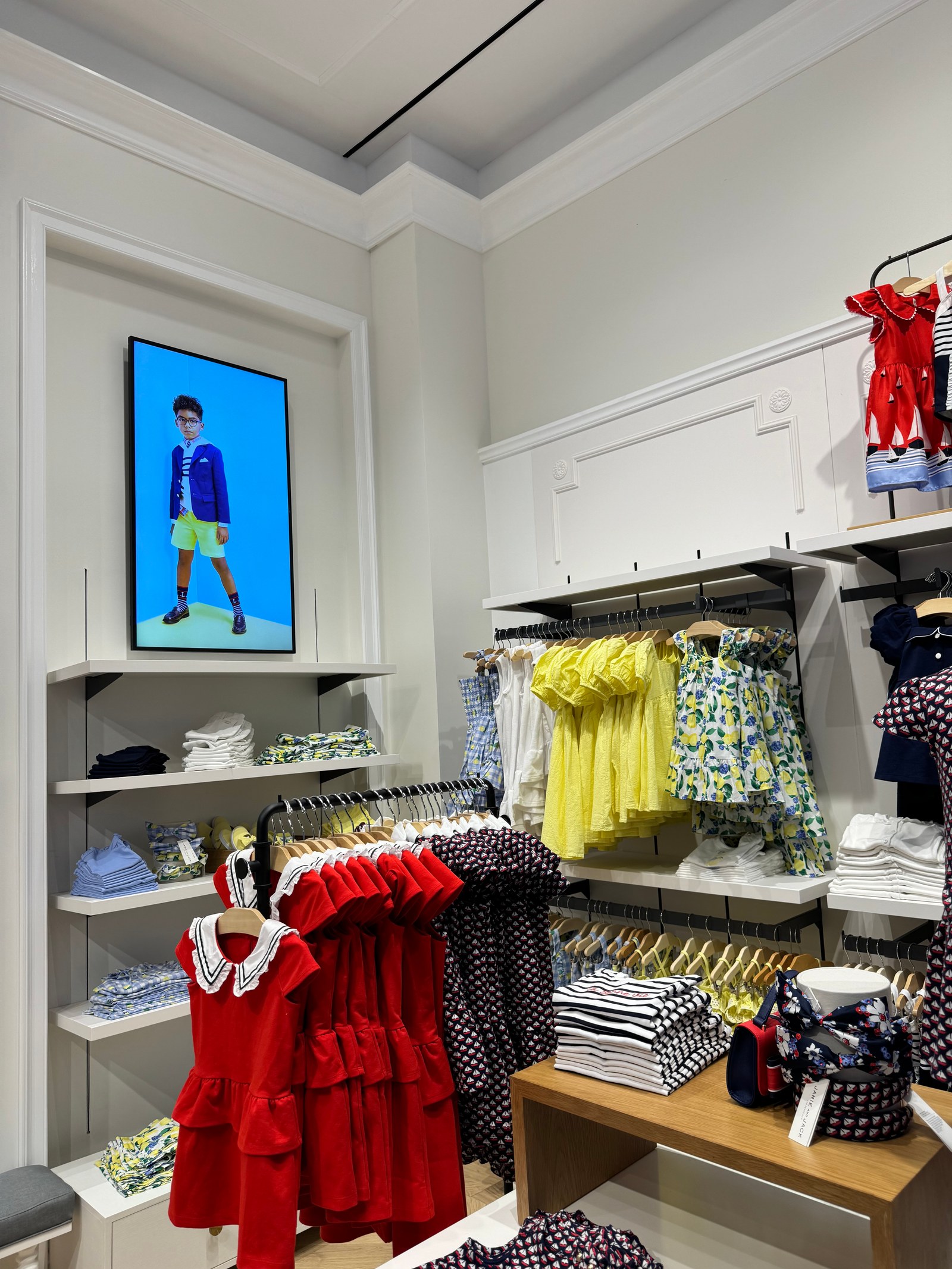 Janie and Jack storefront at Brookfield Place with Samsung digital displays in the windows showing children's apparel campaigns.