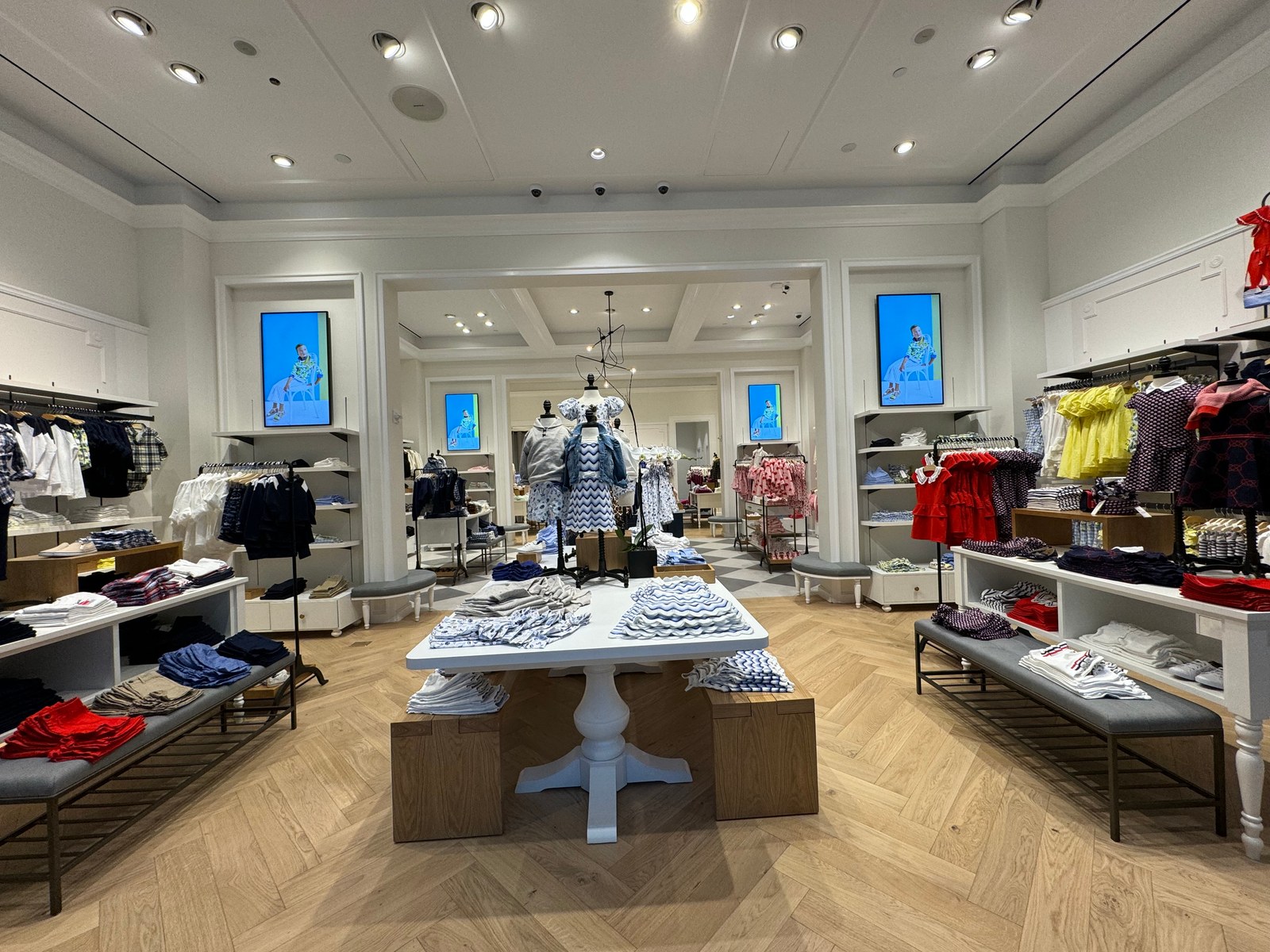 Window-facing Samsung digital display installed in a Janie and Jack storefront, visible in direct daylight.