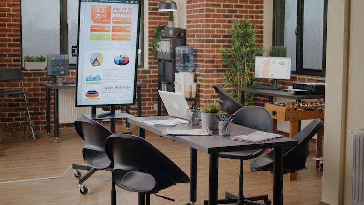 Empty brick wall office with no people at meeting table, business space with modern decorations and technology. Nobody in company workplace with monitor for work presentation.