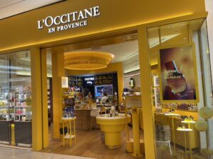 L’Occitane storefront with a large digital display in the front window showing a product campaign.