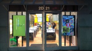 Invicta storefront with two window-facing digital screens showing promotions and visuals.