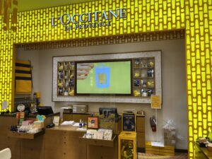 L’Occitane checkout counter with digital screen, testers, and branded in-store signage.