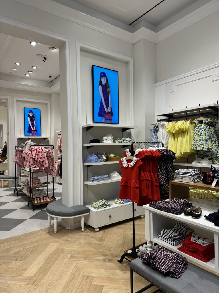 View through boutique doorway with multiple portrait screens leading deeper inside