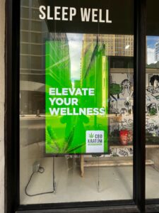 Window digital display promoting wellness products with bright green campaign artwork