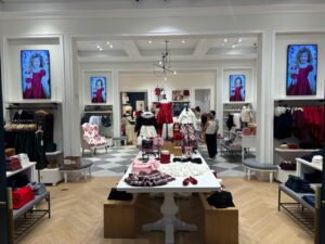 Children’s clothing store with multiple portrait-format digital screens above merchandise displays