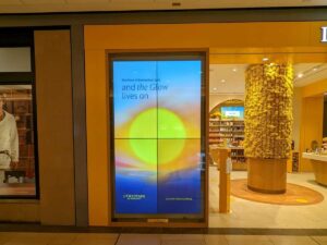 Storefront view with a bright digital display visible through glass from outside.