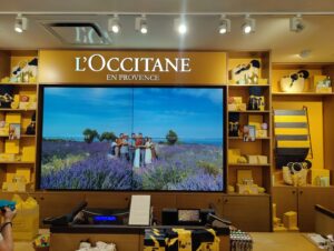 Large-format retail video wall behind checkout showcasing brand content and visuals.