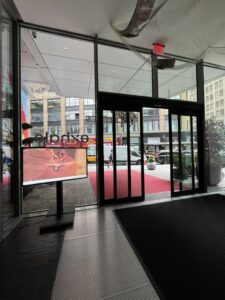 Freestanding digital sign near hotel entrance doors displaying Exhale spa content.