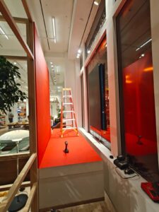 Interior perspective of a vertical window display during installation, showcasing clean alignment, concealed cabling, and minimal visual footprint inside the showroom.