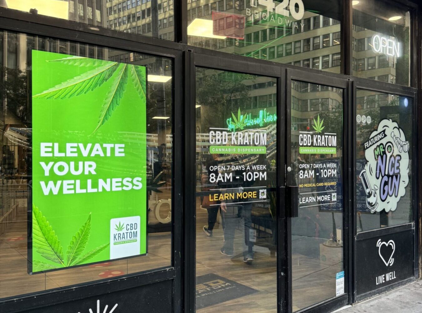 L’Occitane storefront with bright yellow frame and a large digital screen.